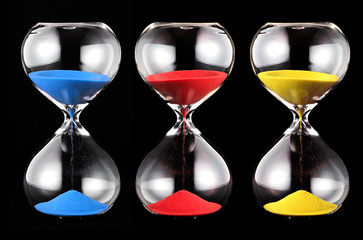Three hourglasses with colorful sand