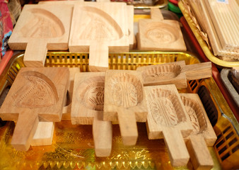 WOODEN BISCUIT MOULD
a wood container with water chestnuts are in front of store.