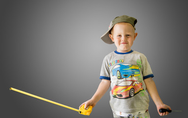 довольный мальчик с рулеткой и отверткой