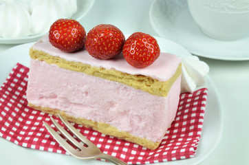 Strawberry Fancy Cake and Whipped Cream / a piece of strawberry fancy cake with whipped cream and pastry fork on white plate, macro, detail, close up, full frame, horizontal