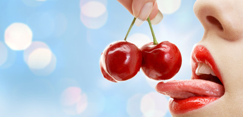 woman mouth with lips and tongue eating cherry