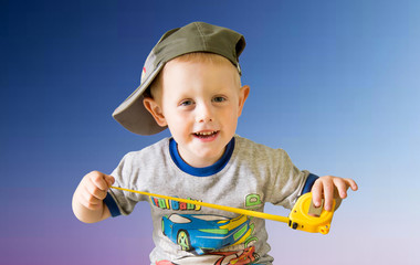 счастливый мальчик с измерительной рулеткой