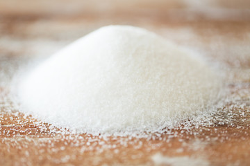 Fototapeta close up of white sugar heap on wooden table obraz