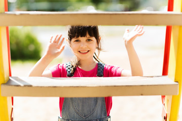 happy little girl climbing on children playground