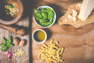 Making pasta with pesto with the original recipe of Genova. Wooden background and accessories communicate the sense of Italy.