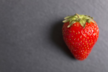 Fresh ripe strawberries on black slate