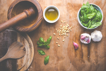 Making pasta with pesto with the original recipe of Genova. Wooden background and accessories communicate the sense of Italy.