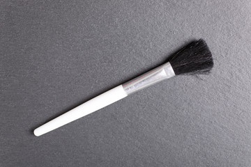 Stylish make up brushes on a black slate surface of all sizes