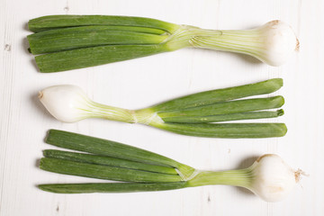 Large spring onion bulbs on a light wooden surface