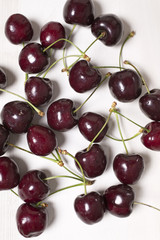 Fresh red cherries on a light wooden kitchen work surface