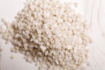 Detail of a pile of white sand on a light wooden surface