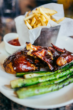Barbecue chicken with asparagus and french fries