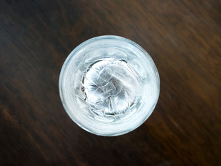Glasses with ice cubes on wooden table