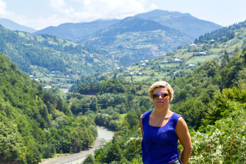 Naklejka premium Woman in sunglasses against the backdrop of a mountain pass