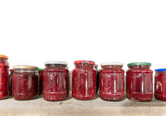 Glass jars with raspberry jam in the cellar