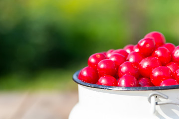 Appetizing red cherry in a white bottle is a close-up