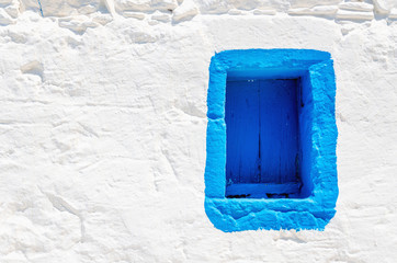 Blue wooden window on white stone wall, Greece - 89942860