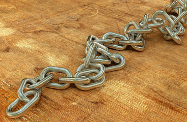Heavy steel chain on a cracked wooden surface background 3d illustration.