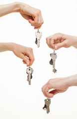 Four hands holding bunches of keys