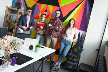 Creative team of four colleagues working in modern office
