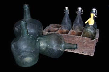 old bottles
old glass bottles and siphon with wooden box with black background