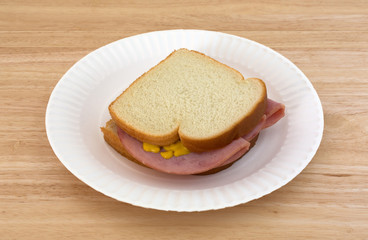 Honey ham sandwich on a paper plate