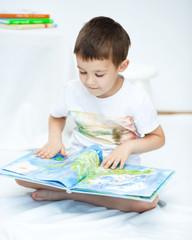 Little boy is reading a book