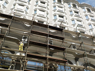 Worker on scaffold working on the facade of the new building-arc