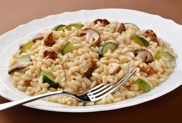 Dish of mushroom zucchini risotto with fork