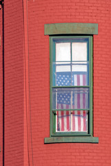 United States Flag Hanging in Window on Red  Brick House