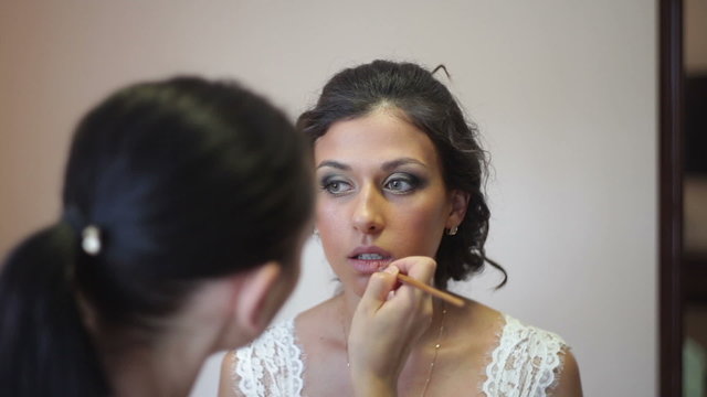 Bride doing makeup on the wedding day
