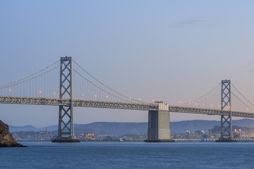 Fototapeta na wymiar San Francisco – Oakland Bay Bridge with lights at sunset time