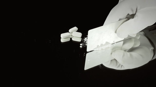 Cocaine and pills on mirror cutting