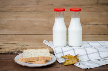 Milk and bread put on old wood.