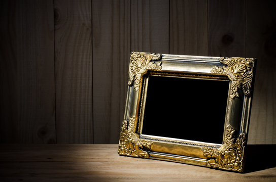 Old picture frame on wood background.