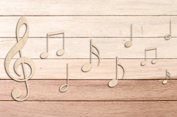 Naklejka premium Music notes on wood background.