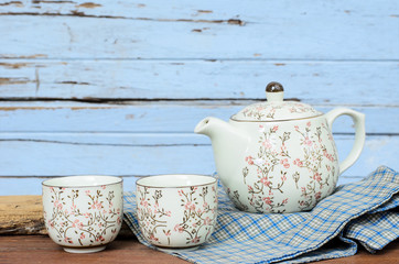 Cup of Tea and Teapot on Wood.