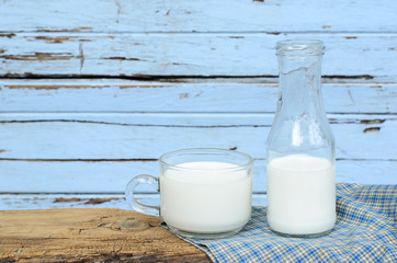 Milk bottle and milk glass put on old wood.