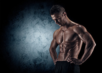 Fototapeta premium Muscular man in studio on dark background