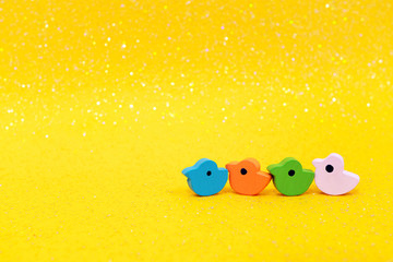 four toy wooden ducks on sparkling yellow background