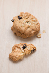 Oatmeal and raisin cookies on wood background.