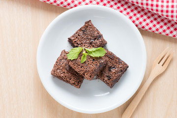 Brownie on white dish, top view.