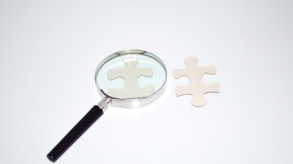 Magnifier with empty puzzle.