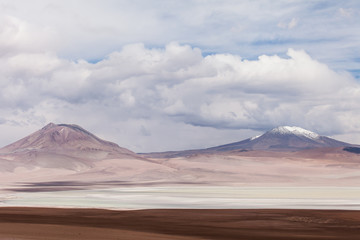 Fototapeta na wymiar Vulcani e lagune sulle Ande. Bolivia. Cielo blu e nuvole bianche sullo sfondo