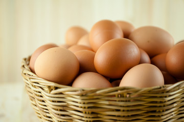 Full of Eggs put in a wicker basket in wooden background