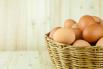 Full of Eggs put in a wicker basket in wooden background