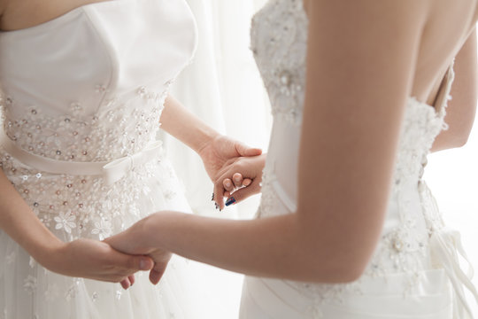 Two brides are willing to connect the hands