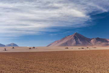 Deserto del Dali. Montagne e rocce in una distesa di sabbia. Cielo blu e montagne sullo sfondo