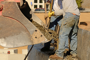 Contractor working on building site installing a retaining wall.