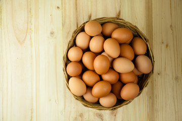 Full of Eggs put in a wicker basket in wooden background